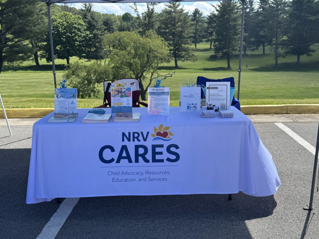 A table adorned with the NRV Cares logo offers pamphlets and other materials at a recent outdoor event