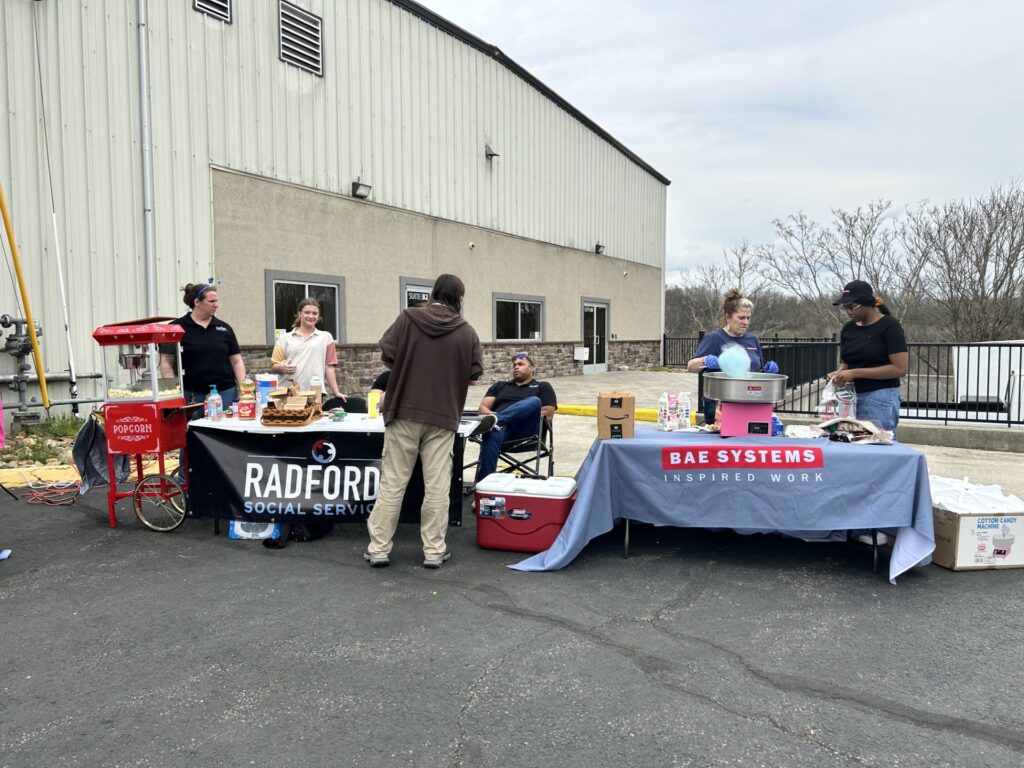 A man with his back to the camera talks to people at a Radford Social Services booth at a recent event
