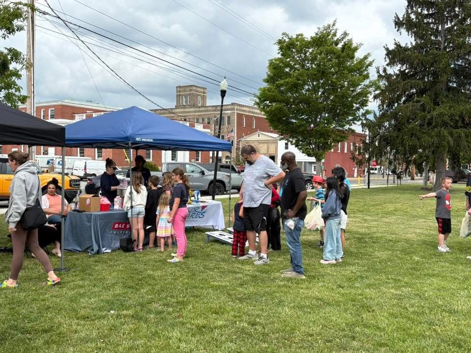 Attendees of the Pulaski County Spring Family Fun Festival standing in the grass beside the different booths